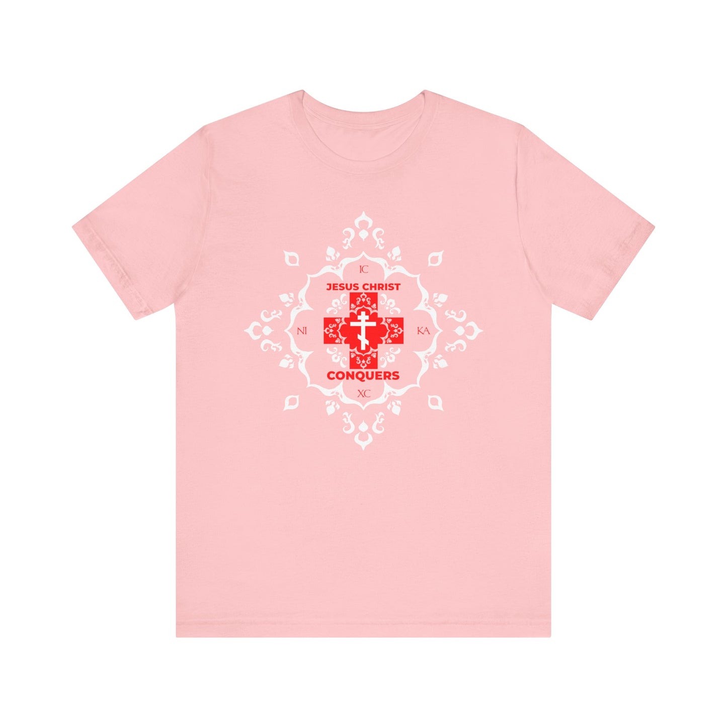 Pink ICXC NIKA tee featuring a white Orthodox cross with red modern font reading "Jesus Christ Conquers" at the center, highlighted by a medieval filigree design and inspired by St. John Chrysostom's teachings—a stylish, lightweight cotton unisex shirt symbolizing victory over sin.