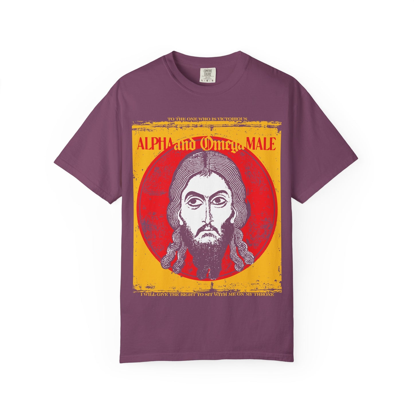 Berry-colored heavyweight cotton unisex tee featuring the Jesus Christ Image of Edessa IkonoGraphic against a vivid red and yellow background, with bold “Alpha & Omega Male” text inspired by Revelation scripture—reflecting Christ as the Alpha and Omega; from the “To the One Who Is Victorious” Orthodox collection.