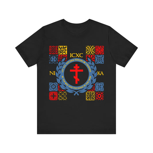Black Let All Adverse Powers Be Crushed t-shirt with red, yellow, and blue medieval tile design inspired by Orthodox Christian art—featuring ICXC NIKA and motifs from the Katavasia of the Cross and Moses at the Red Sea.