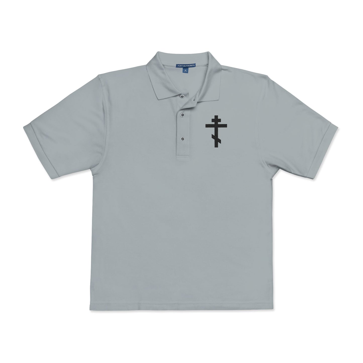 Cool grey polo shirt featuring an embroidered black Orthodox cross with the inscription “May I never boast, except in the cross of our Lord Jesus Christ” (Gal 6:14) on the left chest. Christian-inspired design.