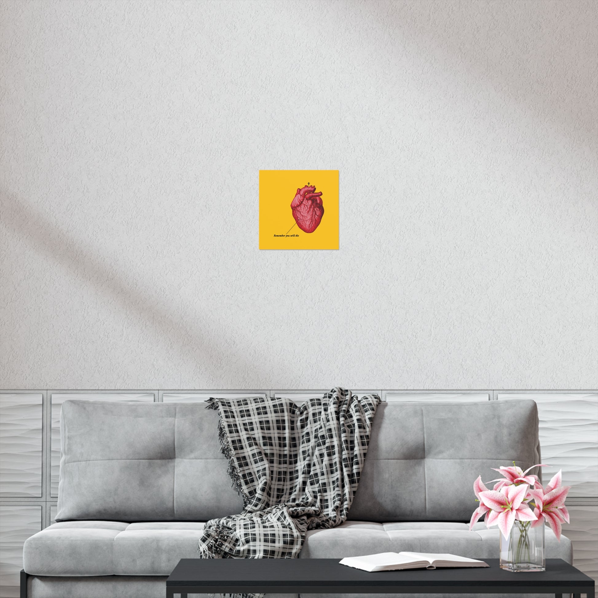 A gray sofa with a plaid blanket, pink flowers, and the "Remember You Will Die" Christian art poster featuring a retro medical heart and Orthodox cross creates a peaceful space—ideal for reflection and quiet moments.