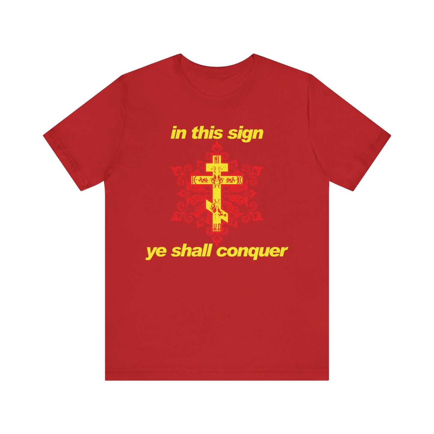 Rewritten Sentence: The "In This Sign Ye Shall Conquer" Orthodox Christian t-shirt features a striking red color with a yellow cross and modern typography displaying the phrase “in this sign ye shall conquer” above and below the cross, drawing inspiration from St. Theophan the Recluse’s wisdom on prayer against temptation.
