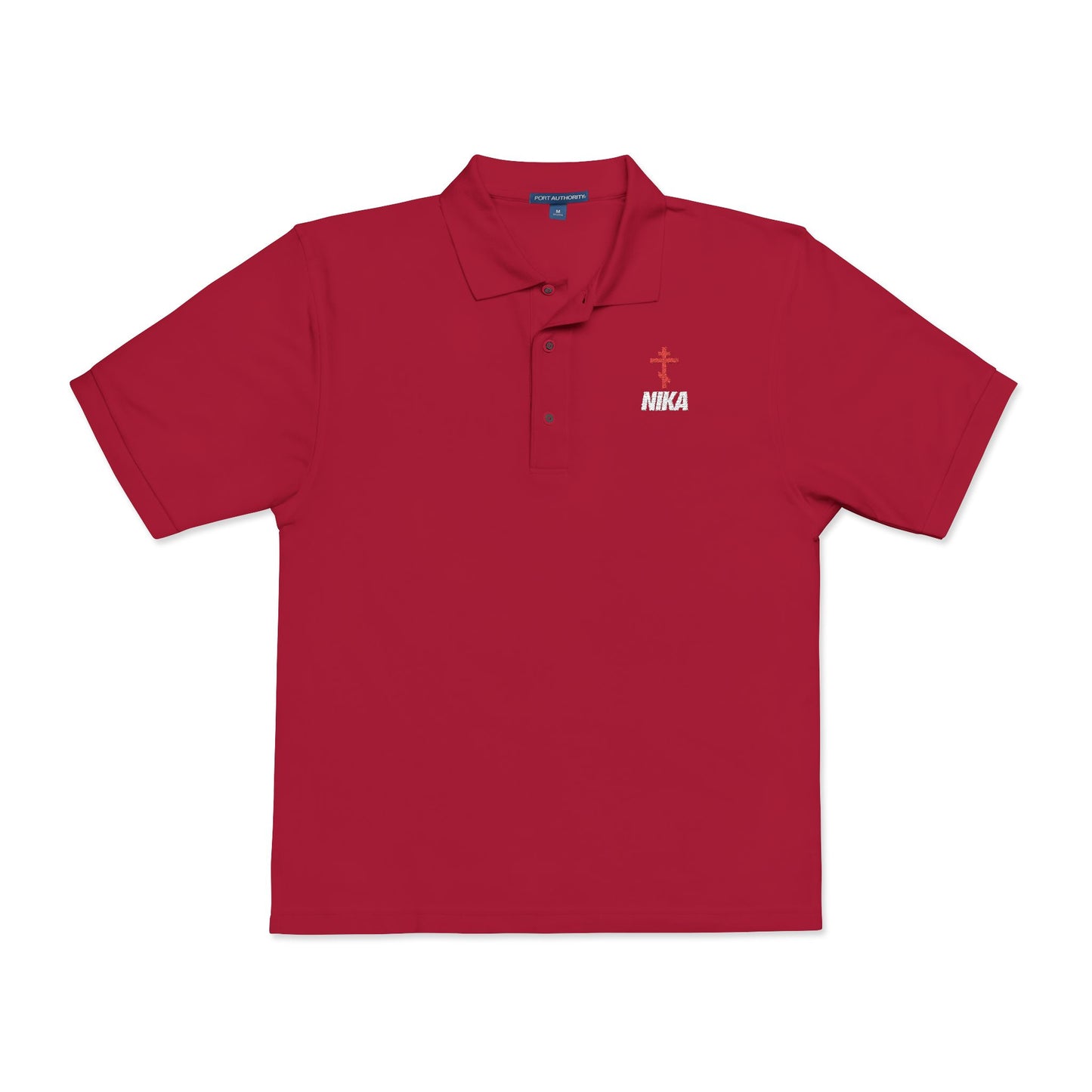 Red athletic polo with collar, buttons, and a small NIKA Orthodox Cross logo in white—Christian embroidered design blending NIKE style and spiritual meaning. "Jesus Christ Conquers" accent celebrates athletic ascetic fashion.