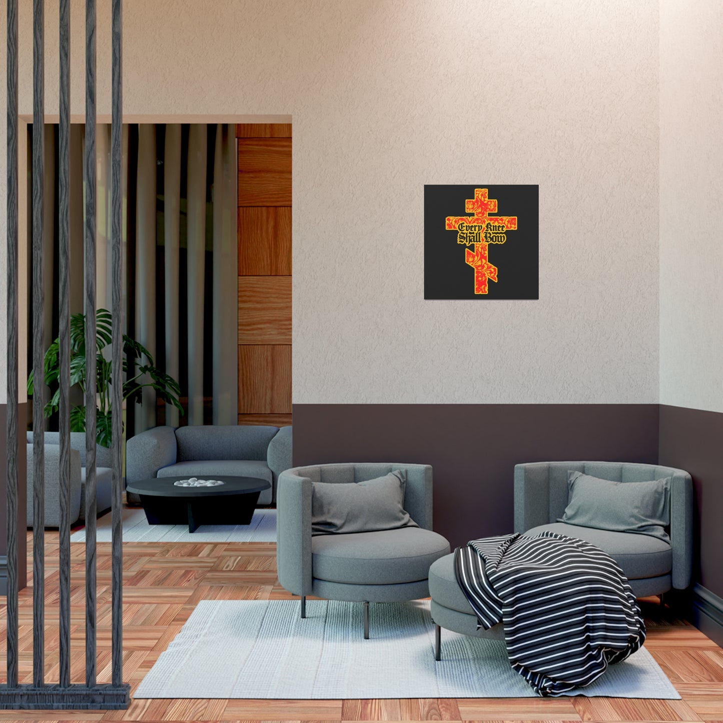 Modern living room featuring gray chairs, round table, and the "Every Knee Shall Bow" Christian art poster— a gold and red floral Orthodox cross with gothic lettering—reflecting Isaiah 45:22-24 and Philippians 2:7-11.