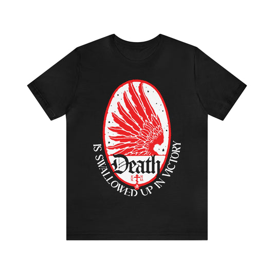 The "Death is Swallowed Up In Victory No. 3 (1 Cor 15:54)" Orthodox Christian T-Shirt features a red angel wing on black, with the text "Death is swallowed up in victory," symbolizing immortality and incorruption.
