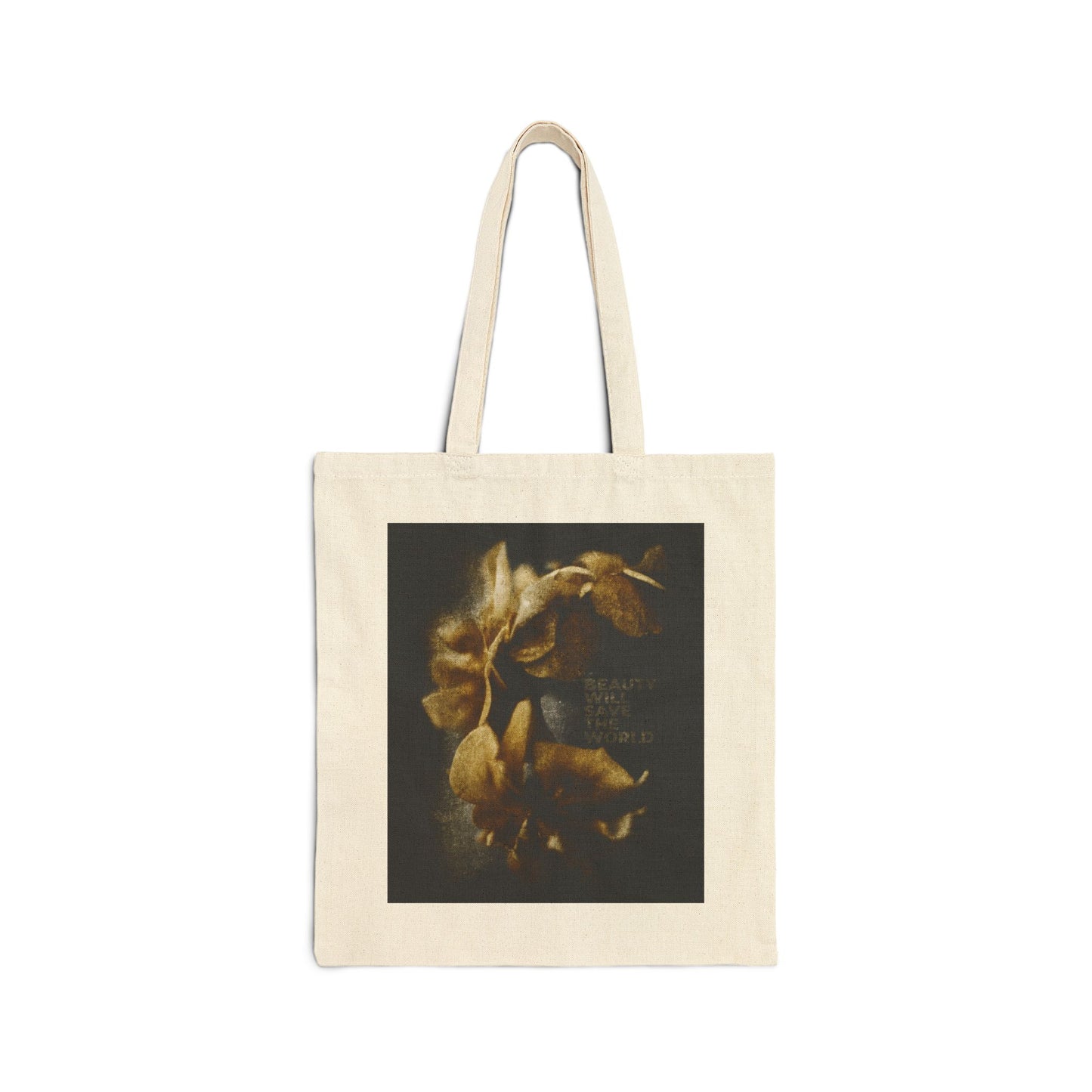 Natural tote bag featuring a dark square photographic print with yellowish flowers and faint text, titled "Beauty Will Save the World." This Christian tote celebrates Jesus Christ as Universal Creator & King.