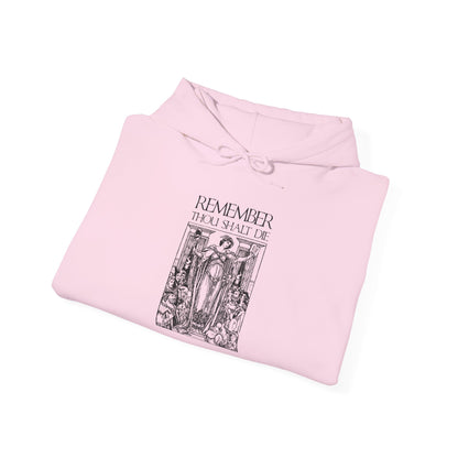 A folded pink Orthodox Christian hoodie featuring the “Remember You Will Die” Shakespearean design, with classic woodcut illustration aesthetic and memento mori theme inspired by St. Ephraim the Syrian’s reflections on death.