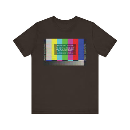 Brown T-shirt featuring an Emergency Broadcast System TV test pattern and glitchy white text across the center, inspired by 1 Peter 4:7 and apocalyptic Christian themes, subtly reflecting messages of kindness and love.