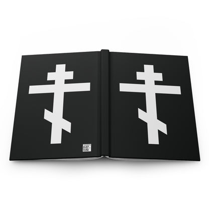 A black Orthodox Hardcover Journal featuring two white Orthodox crosses, inspired by Galatians 6:14: "May I never boast, except in the cross of our Lord Jesus Christ.