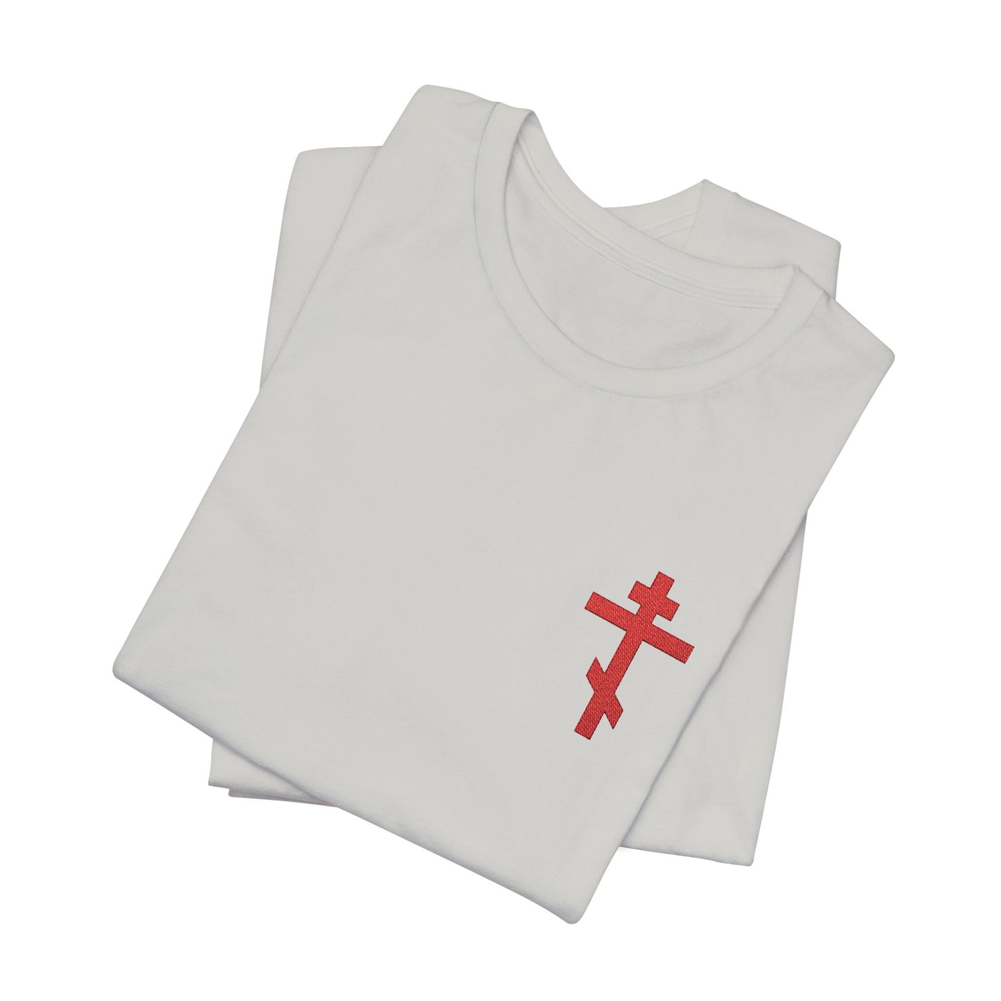 Two folded white t-shirts display a small red embroidered Orthodox cross inspired by Galatians 6:14 and the phrase "May I Never Boast Except in the Cross" on the front.