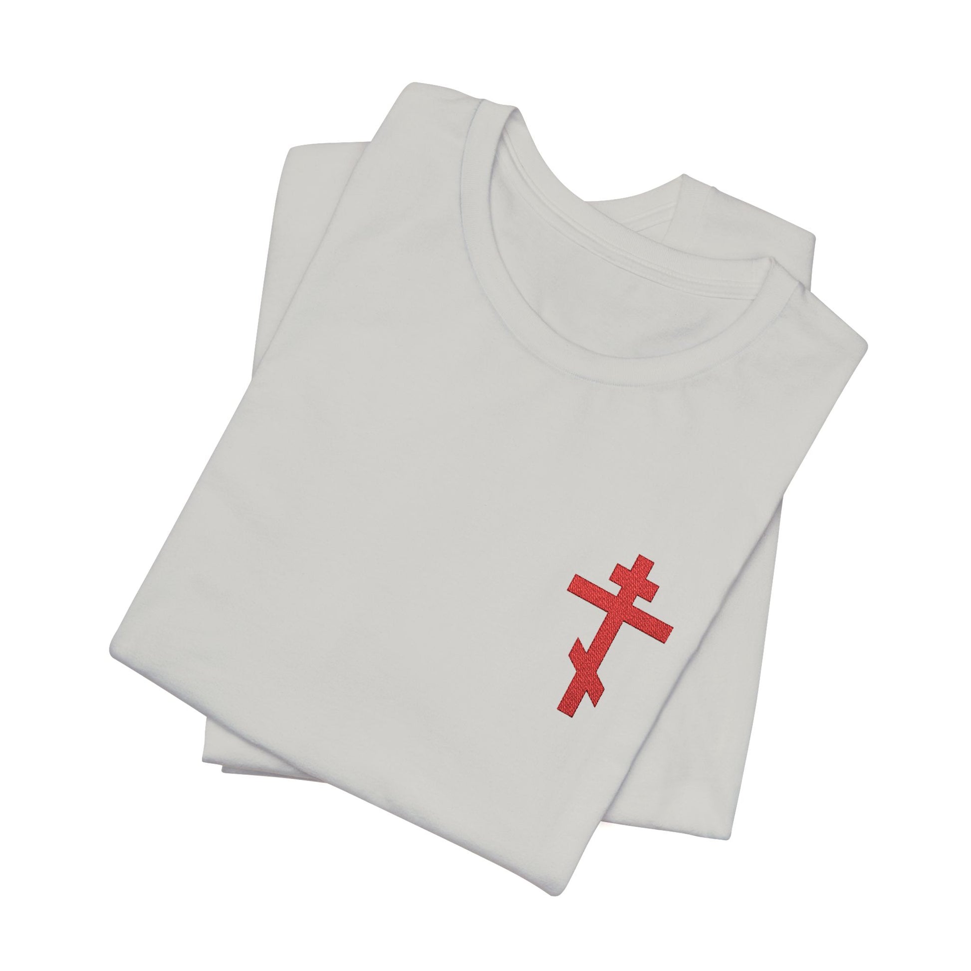 Two folded white t-shirts display a small red embroidered Orthodox cross inspired by Galatians 6:14 and the phrase "May I Never Boast Except in the Cross" on the front.