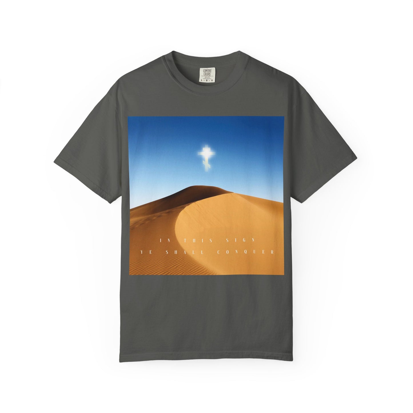 Pepper-colored heavyweight cotton unisex tee featuring a desert sun scene with a glowing cross in the sky symbolizing the Elevation of the Cross, and text that reads “IN THIS SIGN YE SHALL CONQUER.”.