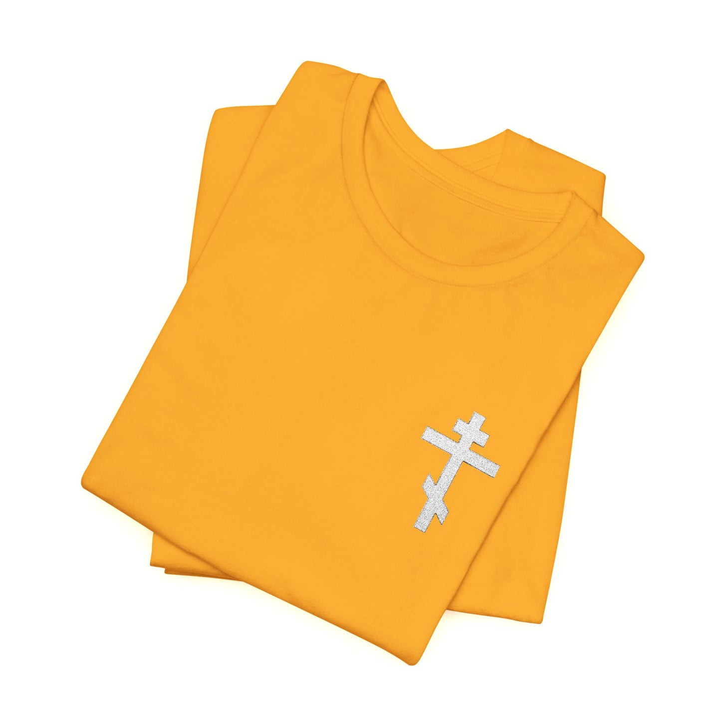 Folded yellow T-shirt featuring a small white embroidered Orthodox cross, inspired by Galatians 6:14—"May I Never Boast Except in the Cross of Our Lord Jesus Christ." Perfect for expressing your Christian faith subtly and stylishly.
