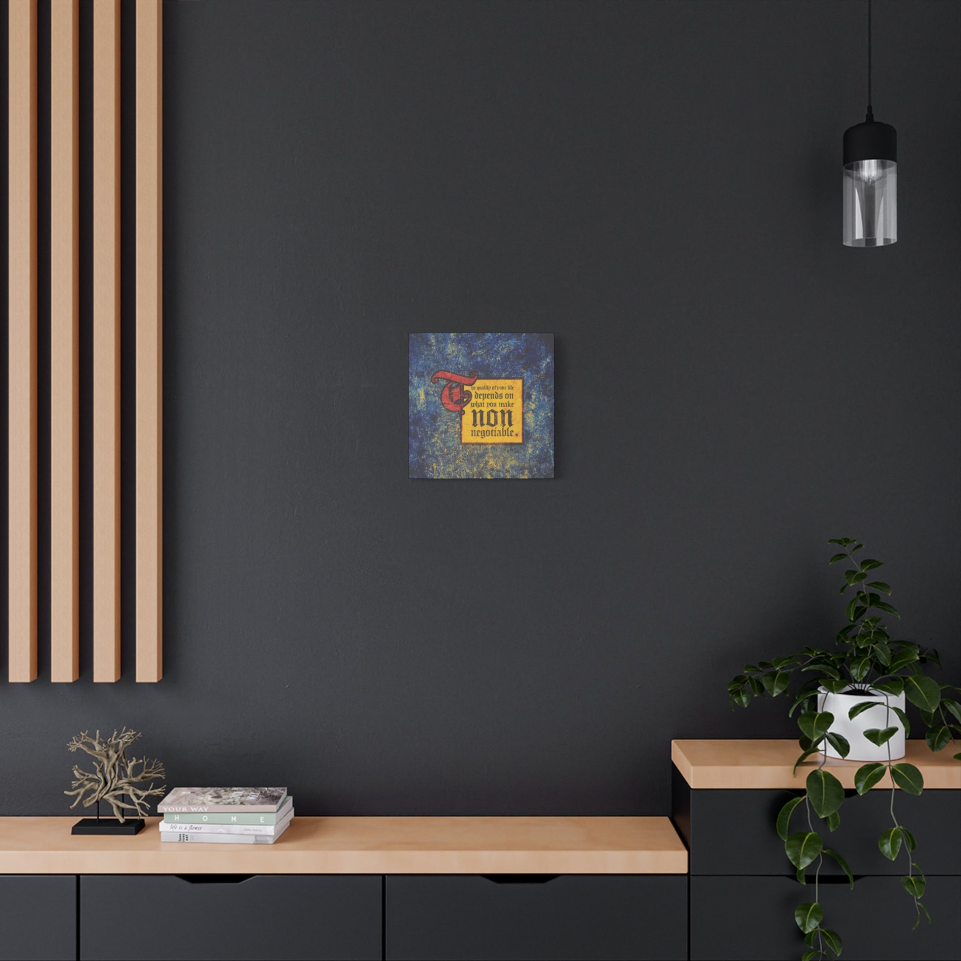 A modern black and wood room features "The Quality of Your Life Depends on What You Make Non-Negotiable" Christian wall art, plus books, a plant, and a pendant light—essential touches for an inspiring, faith-filled space.