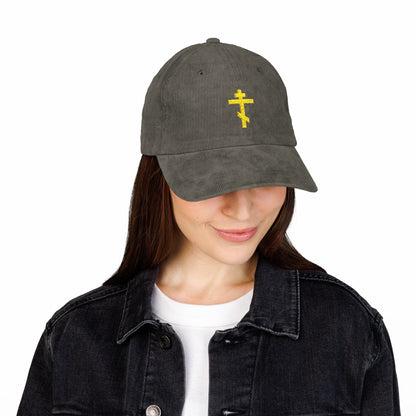 Woman wearing the Simple Yellow Orthodox TriBar Cross Embroidered Cotton Corduroy Cap—Weapon of Unseen Warfare Which Makes Demons Tremble—shows quiet reflection in her black denim jacket and white shirt.
