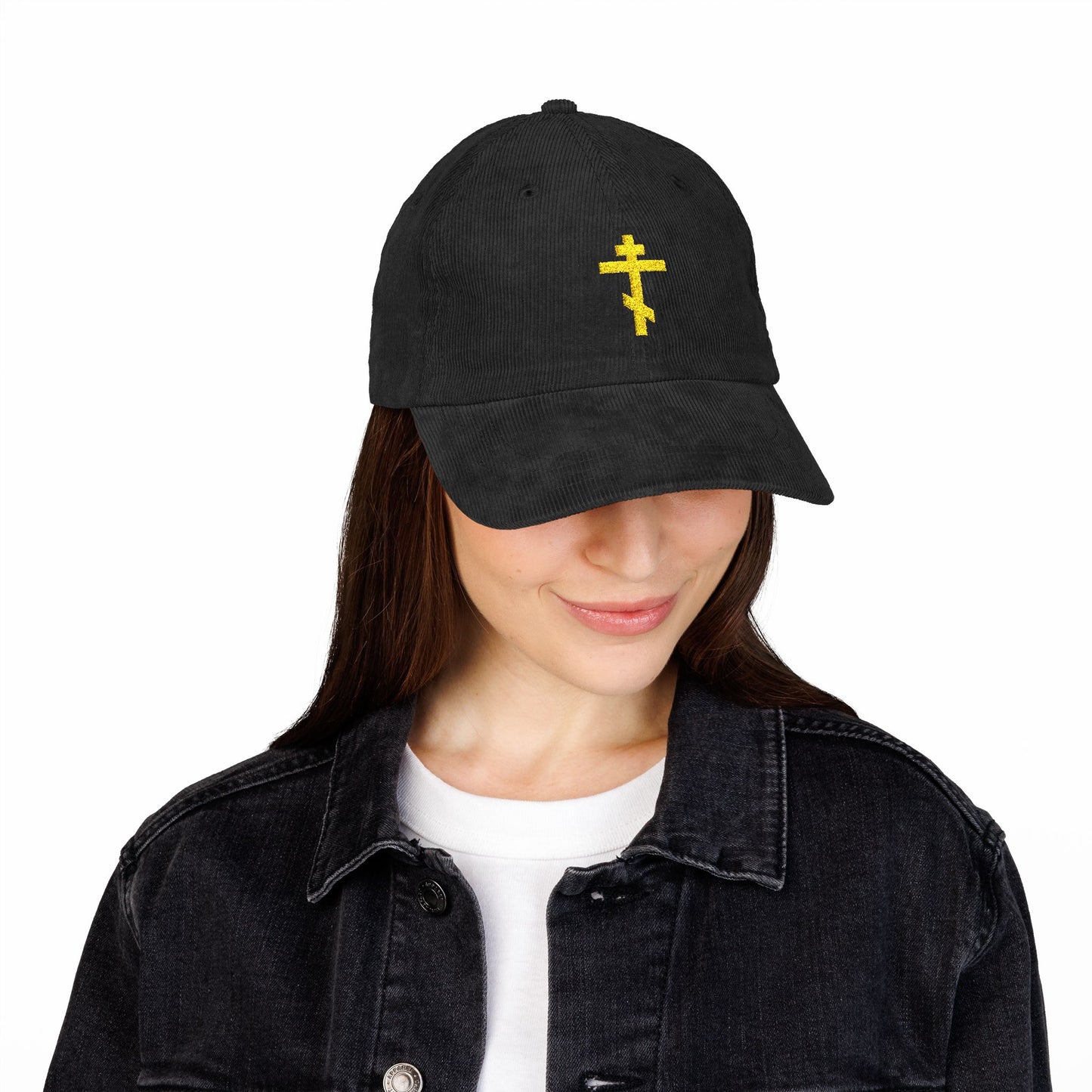 A woman smiles downward, quietly hopeful, wearing the Simple Yellow Orthodox TriBar Cross Embroidered Cotton Corduroy Cap—Orthodox Christian headwear known as a Weapon of Unseen Warfare Which Makes Demons Tremble.