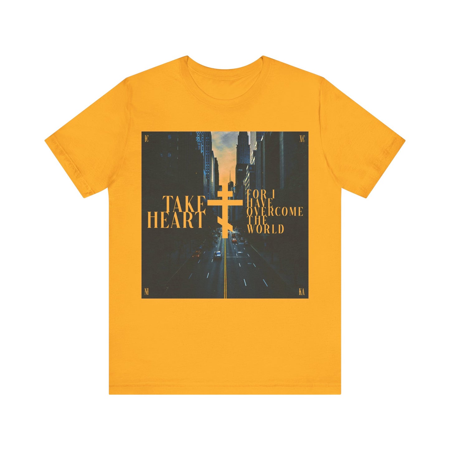 Gold cotton t-shirt featuring a modern city street scene and the text "Take Heart, For I Have Overcome the World" (John 16:33), inspiring hope and joy. Orthodox Christian design.