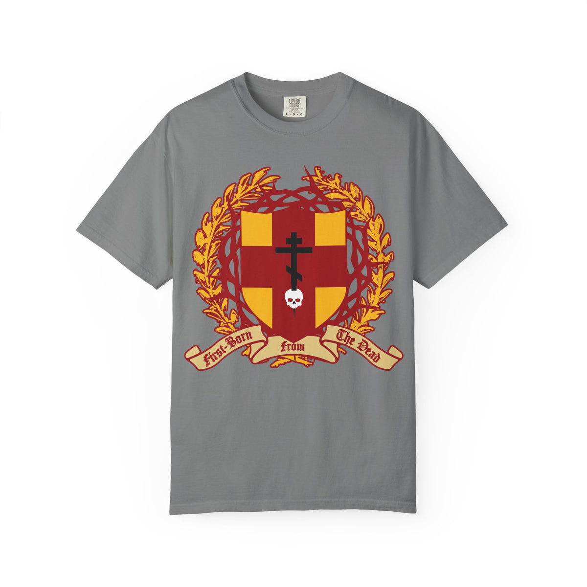 Grey heavyweight cotton unisex t-shirt featuring a heraldic shield with an Orthodox cross piercing a skull, a crown of thorns, and laurel wreath, plus a red and gold ribbon reading “First-Born from the Dead”—a striking design inspired by Colossians 1:18 about Christ’s redemption.