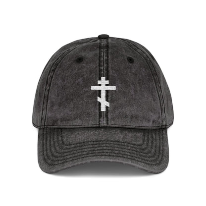 A black distressed cap featuring a simple white Orthodox TriBar Cross and "Crucify My Ego to the Precious and Life Giving Cross" embroidered, combining minimalist Christian style with deep symbolism.