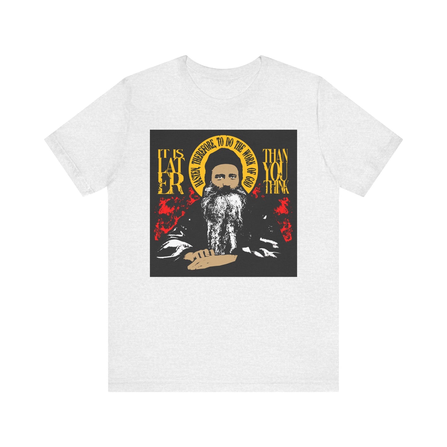 Ash-colored lightweight cotton unisex tee featuring red and yellow artwork of a bearded man with a halo and the text: “It is later than you think, hasten therefore to do the work of God” (Fr Seraphim Rose)—a striking nod to Orthodox spiritual literature and the call to spiritual discipline.