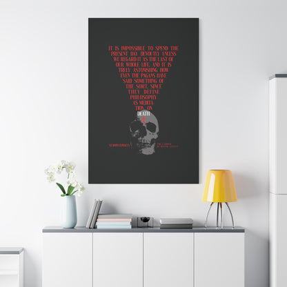 The Present Day As the Last Day of Our Life" Orthodox canvas wall art, featuring a skull with a red cross and inspired by St John Climacus’s memento mori meditation, displayed above a modern minimalist white cabinet, lamp, and flowers.