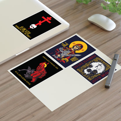 Four Orthodox stickers from the Bestseller Mix No. 1 set—including Theotokos Champion Leader, St Marina, Death Where is Thy Victory, and To Live is Christ—rest alongside a pen on a wooden desk beside a laptop and mouse, offering daily inspiration and gentle remembrance of mortality.