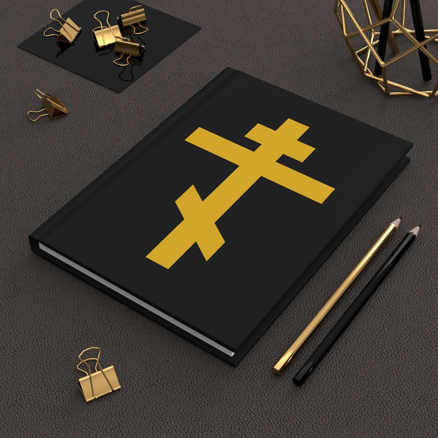 Yellow Orthodox Cross Black Background Orthodox Hardcover Journal—Precious and Life-Giving Weapon of Unseen Warfare, Scourge of Demons—featured with two pencils and gold binder clips, inspired by Galatians 2:20.