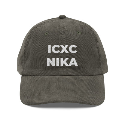 An olive cotton corduroy cap with "ICXC NIKA"—Greek for "Jesus Christ Conquers"—embroidered in white on the front.