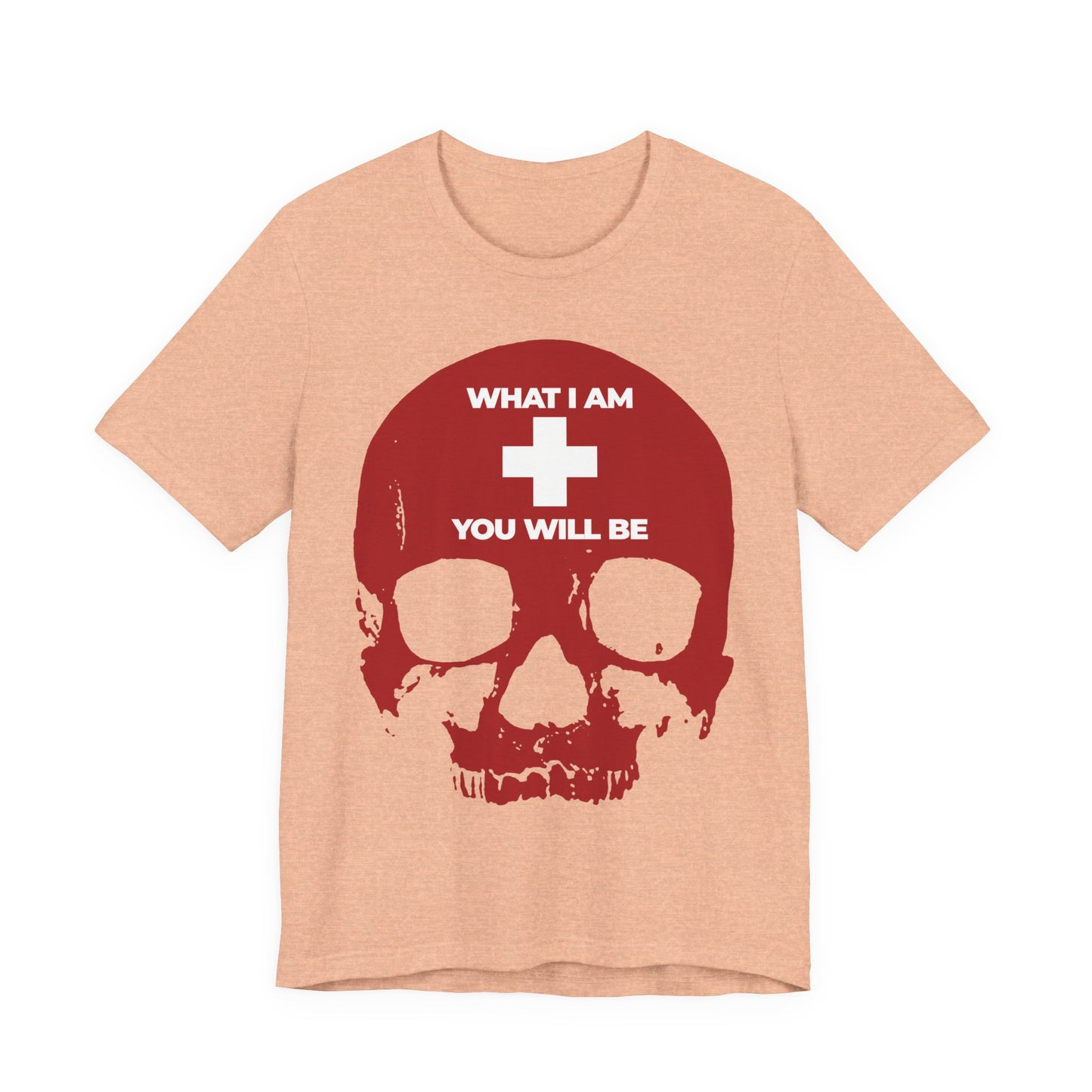 Heather peach t-shirt featuring a red skull, white cross, and the words “WHAT I AM YOU WILL BE” above and below the cross—a striking memento mori design inspired by Ecclesiastes.