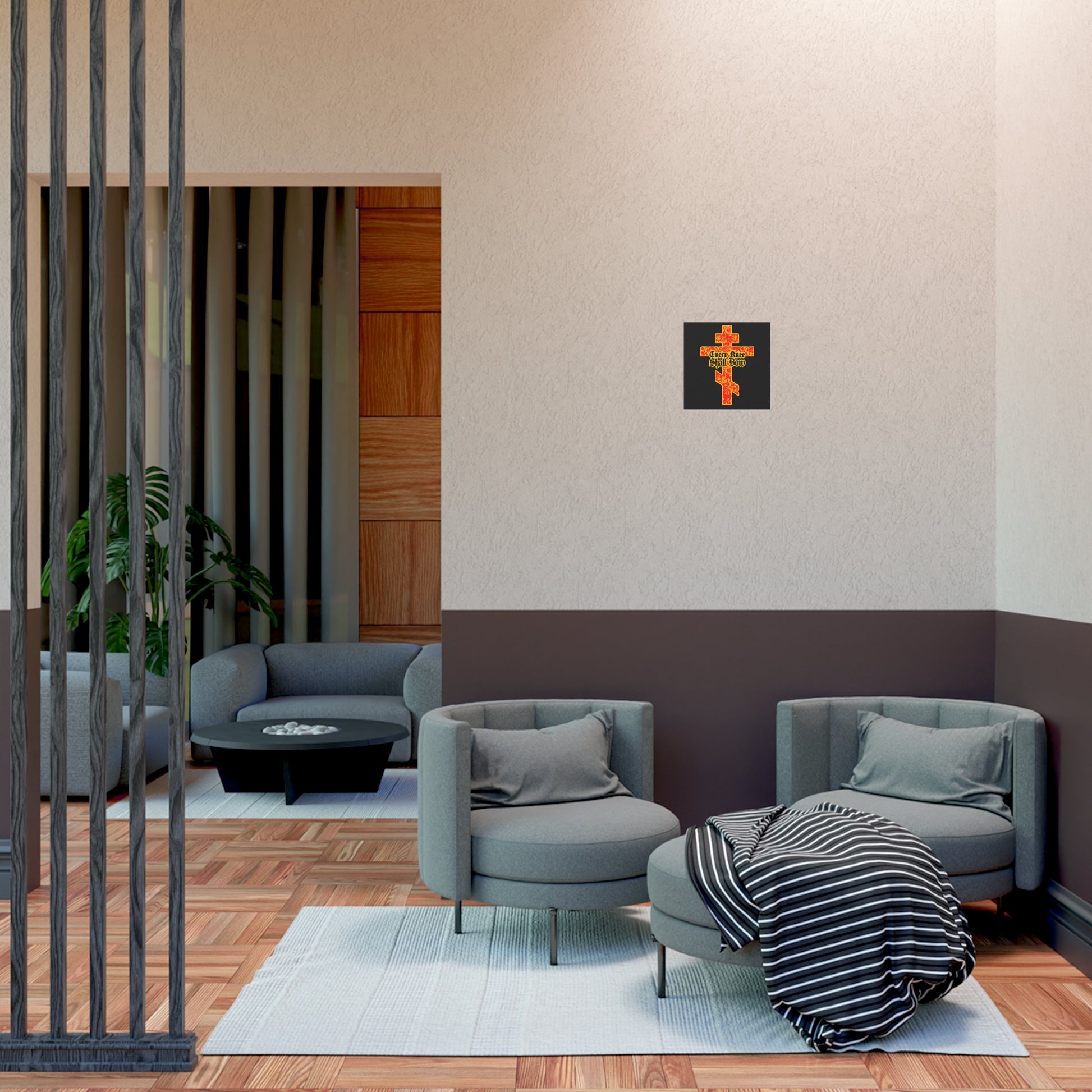 A modern living room with gray chairs, a round table, a blanket, and the "Every Knee Shall Bow" Christian Art Poster—featuring a gold and red floral Orthodox cross—brings serenity, righteousness, and strength to the space.