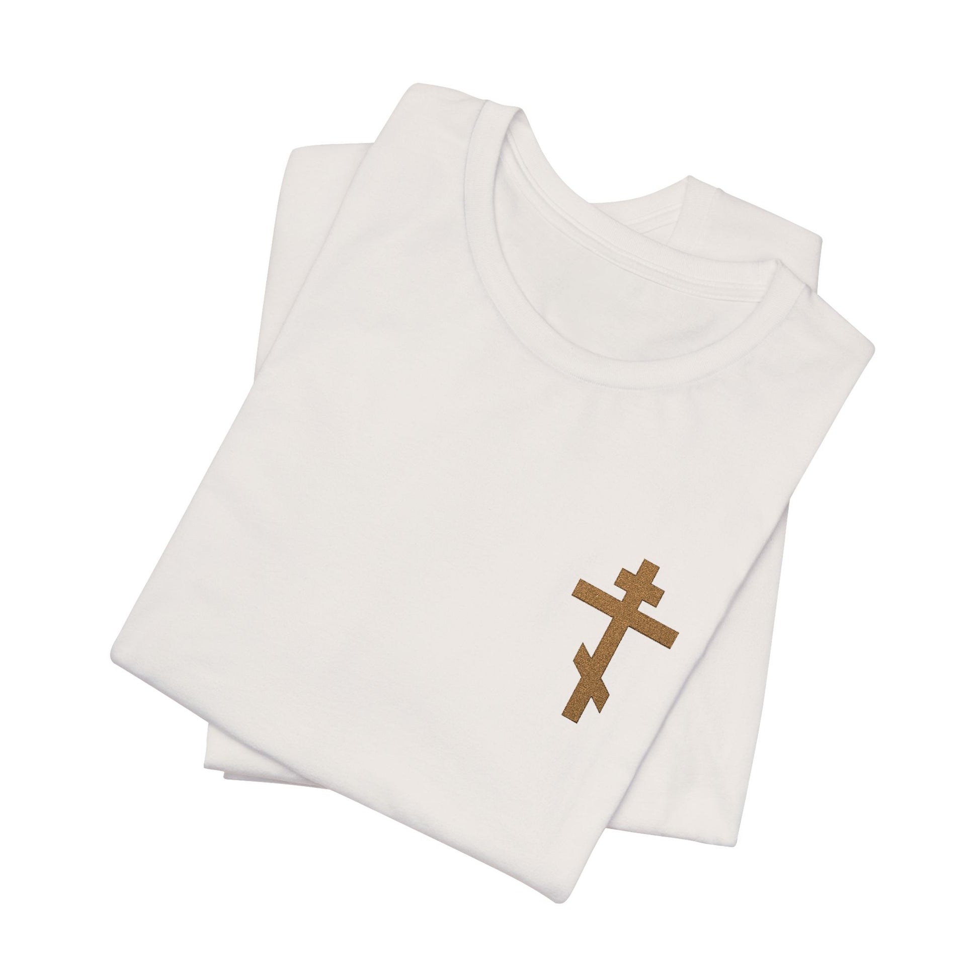 Two folded earthtone t-shirts, each with a small embroidered Orthodox cross on the front left, inspired by Galatians 6:14—"May I Never Boast Except in the Cross." Christian cotton unisex design.