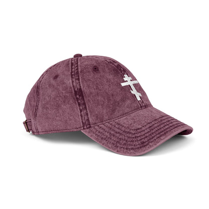 Maroon cap featuring a simple white Orthodox TriBar cross embroidered on the front, symbolizing the Crucify My Ego to the Precious and Life Giving Cross design. Minimalist Christian distressed style.
