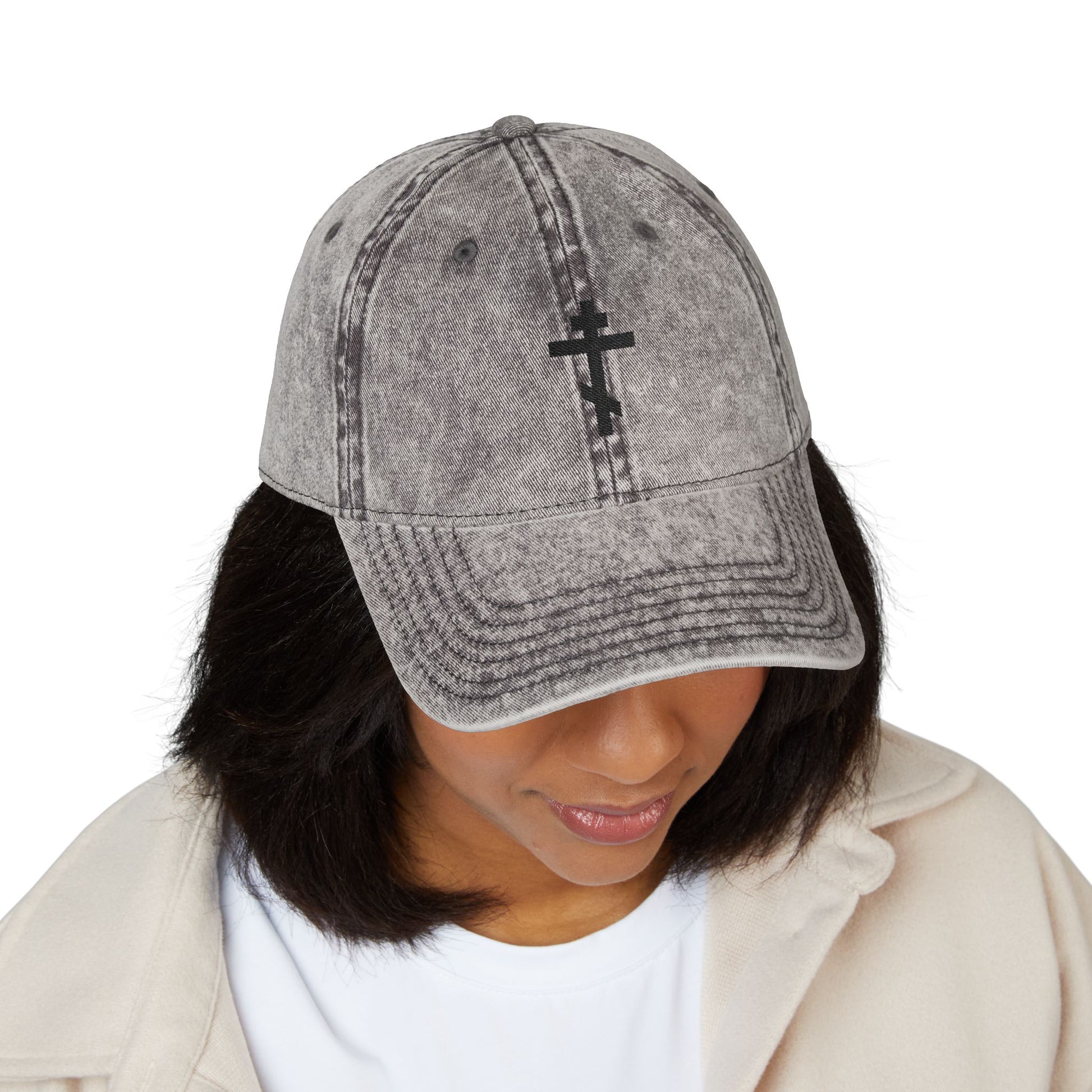 Person wearing the Simple Black Orthodox TriBar Cross cap, featuring a minimalist distressed design reading "Crucify My Ego to the Precious and Life Giving Cross," looking downward.