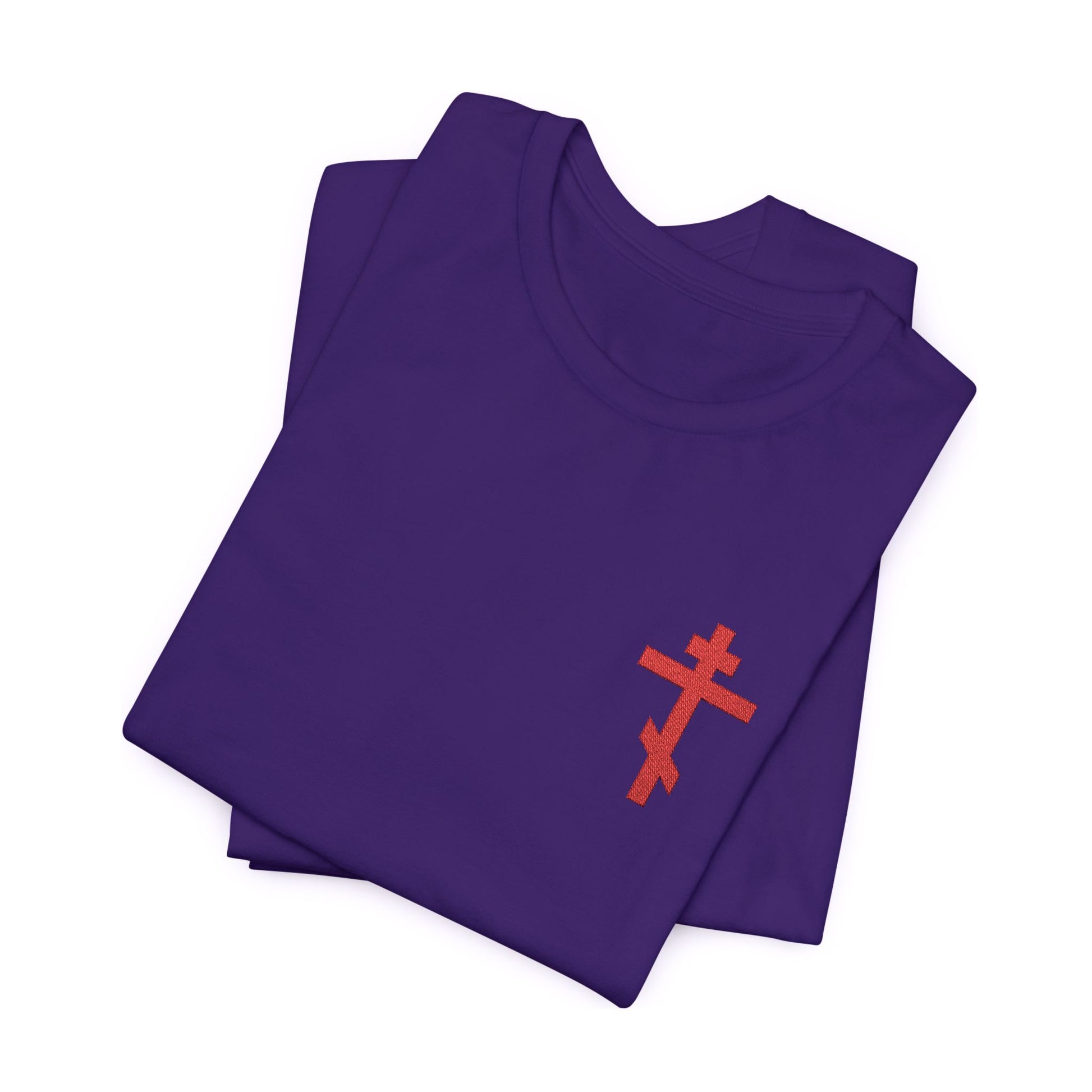 Folded purple cotton unisex t-shirt featuring a small red embroidered Orthodox cross inspired by Galatians 6:14, with "May I Never Boast Except in the Cross" design.