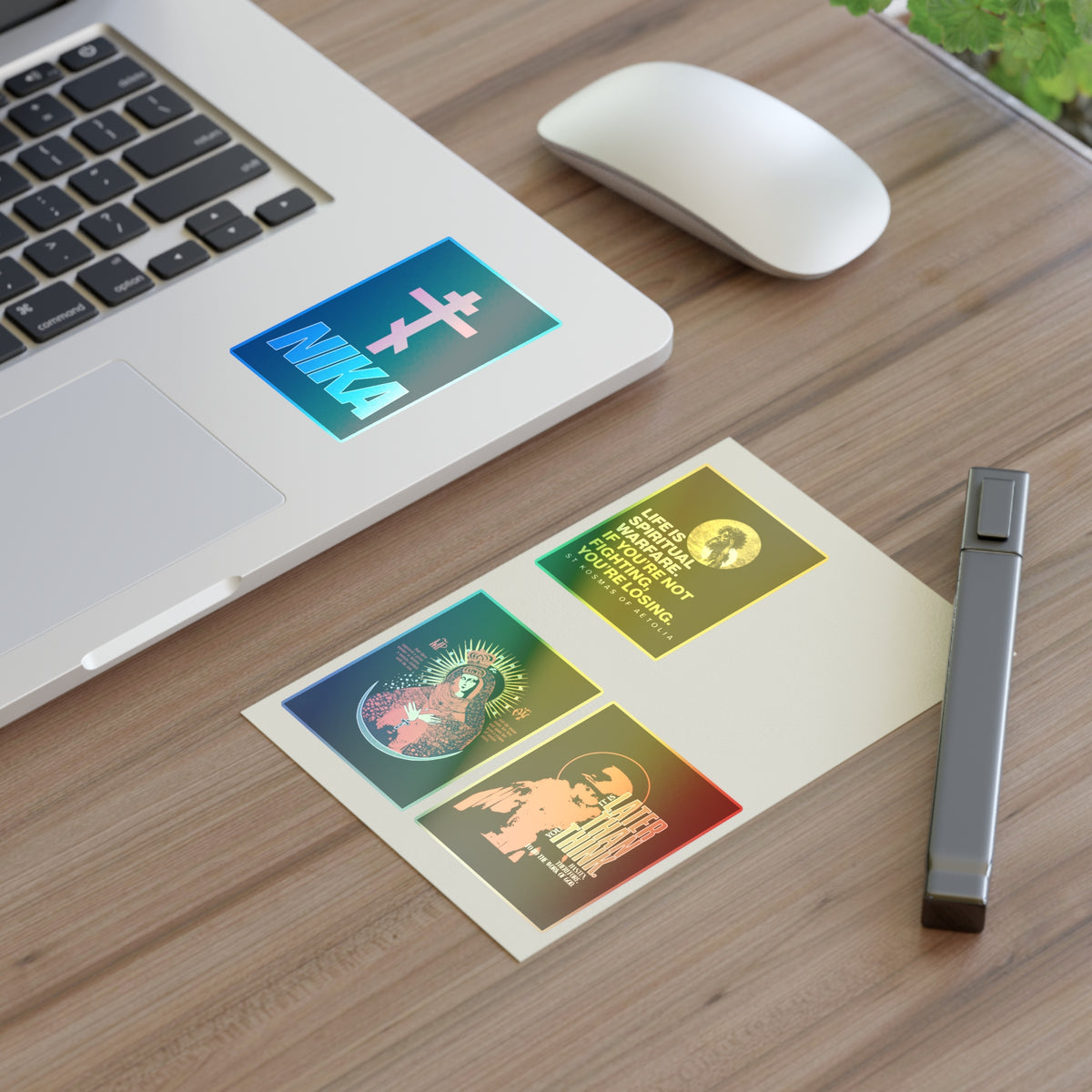 Laptop, mouse, pen on desk with Bestseller Orthodox Sticker Mix No. 5 featuring colorful religious designs.