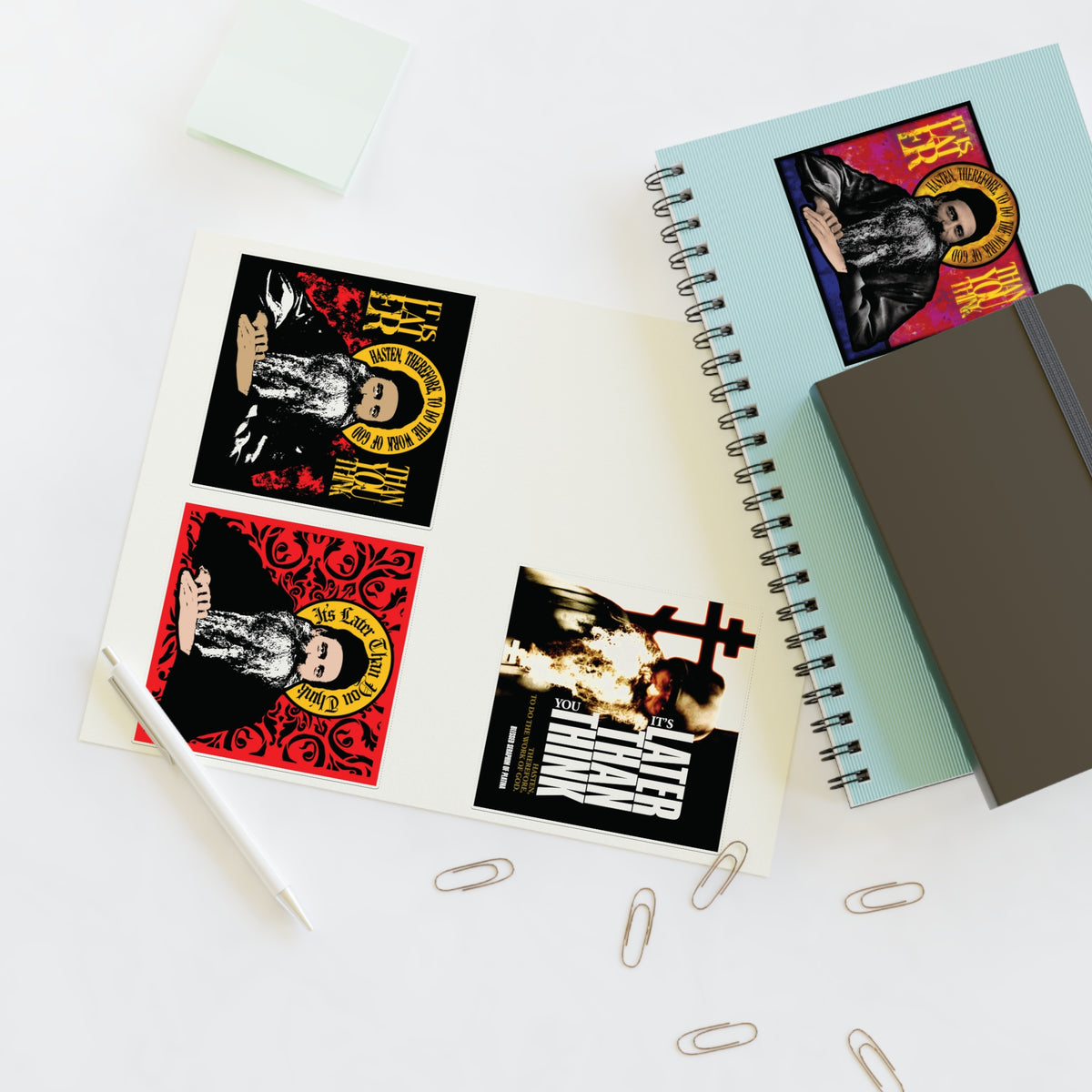 Fr Seraphim Rose Four Sticker Sheet No. 1 with bold designs on a desk next to notebooks and office supplies.