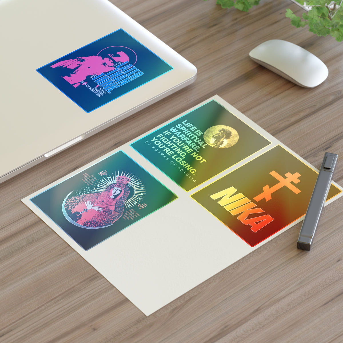Three Bestseller Orthodox Sticker Mix No. 5 and a pen on a desk beside a mouse, laptop, and Orthodox Cross.