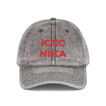 Charcoal grey distressed denim cap embroidered with bold red “ICXC NIKA,” the Orthodox Christian Christogram meaning “Jesus Christ Conquers.”.