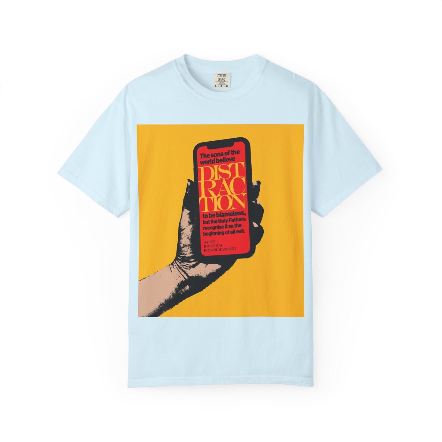 A chambray heavyweight cotton unisex tee titled “Distraction is the Beginning of All Evil (St Ignatius Brianchaninov),” featuring a graphic of a hand holding a phone over a yellow background, inspired by Orthodox Christian teachings and the wisdom of the Holy Fathers.
