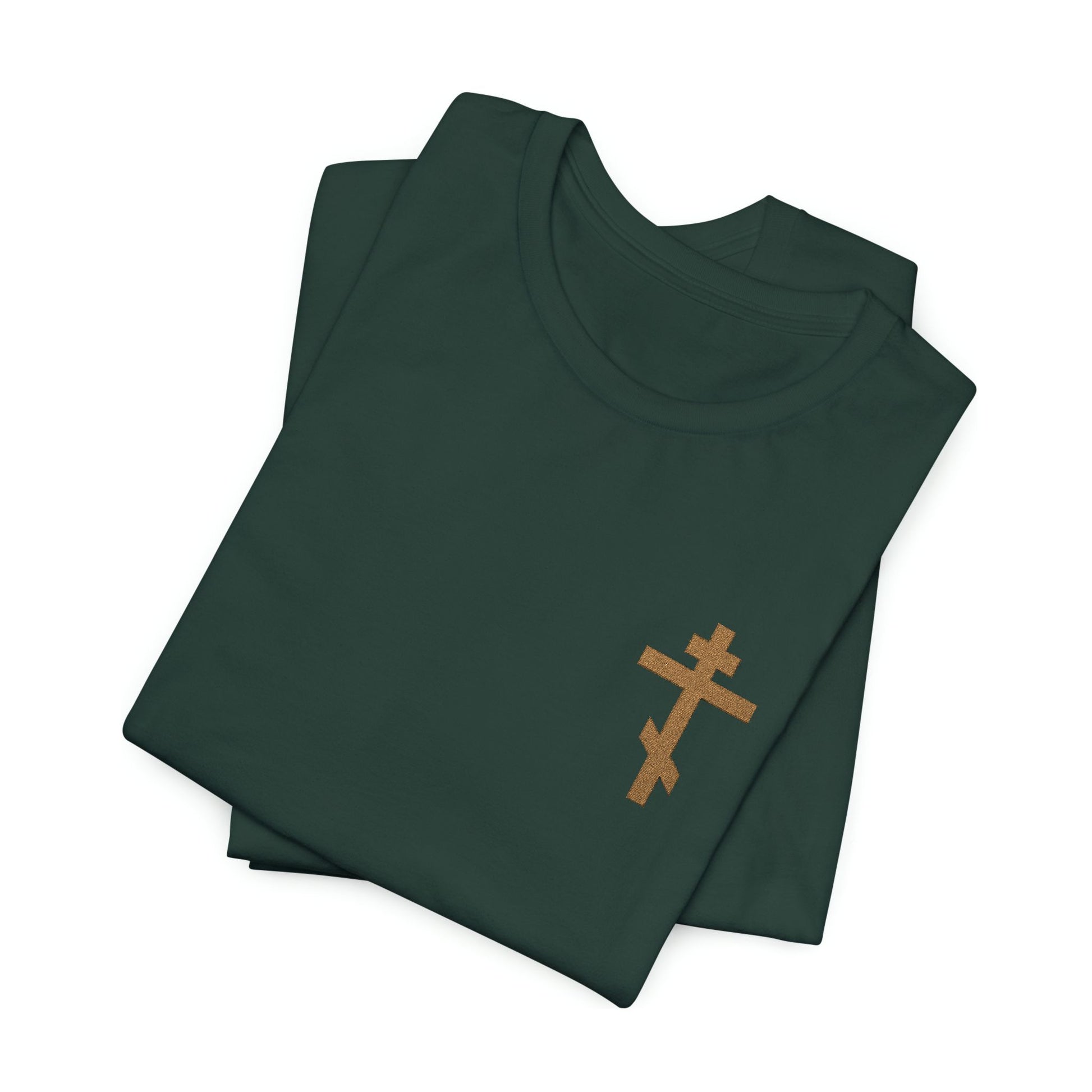 A folded dark green "Small Embroidered Orthodox Cross | Earthtones" unisex t-shirt features a gold cross on the chest and is inspired by Galatians 6:14: “May I Never Boast Except in the Cross.”.