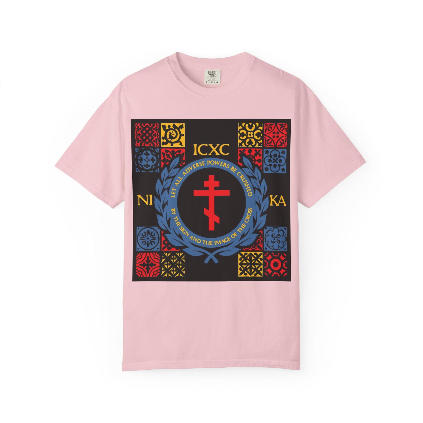 Blossom-colored heavyweight cotton unisex t-shirt featuring the "Let All Adverse Powers Be Crushed" design—a bold, medieval tile-inspired graphic in red, yellow, and blue with a prominent red cross at its center and inscribed with ICXC NIKA.