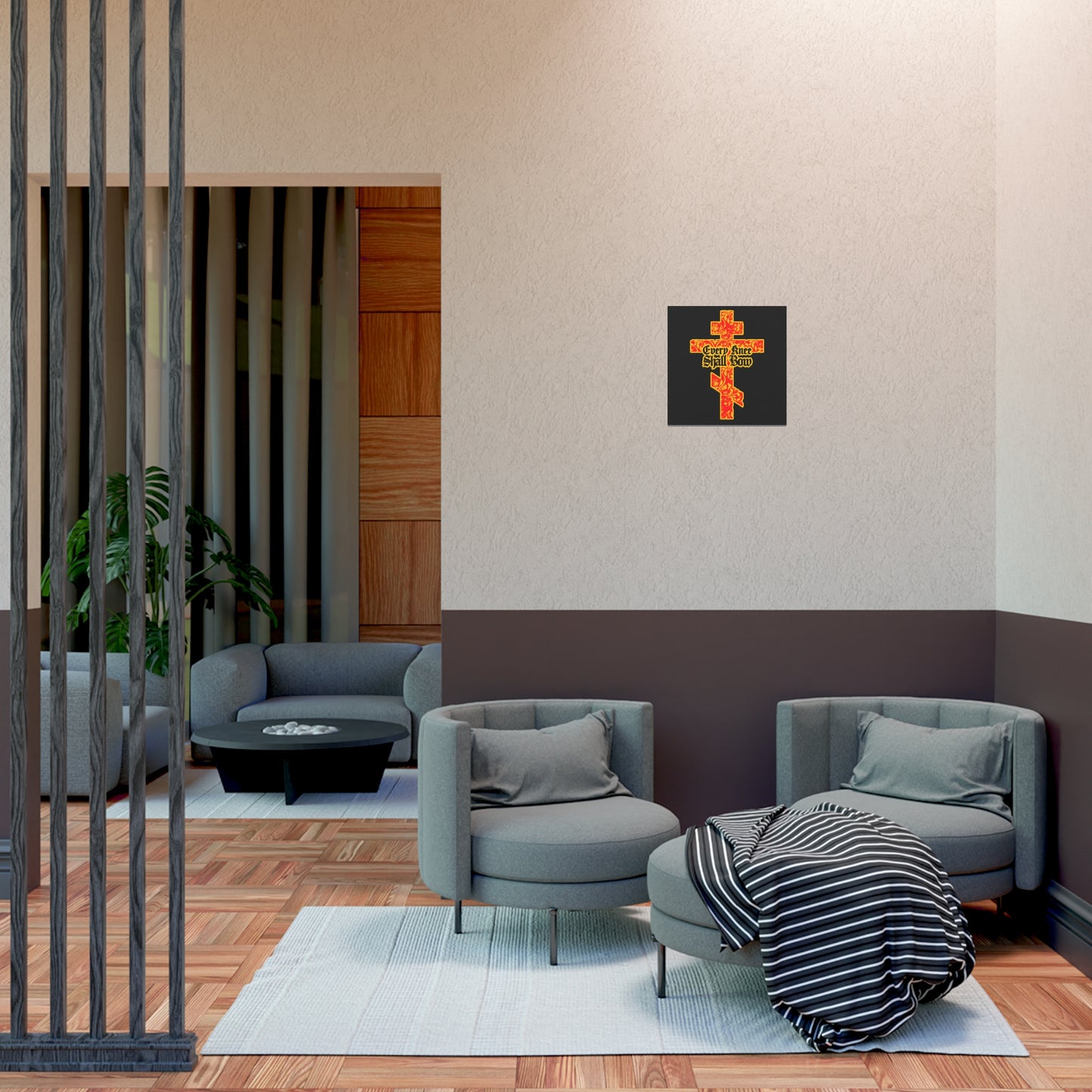 A modern lounge features grey chairs, a striped blanket, and the "Every Knee Shall Bow" Christian art poster—gold and red floral Orthodox cross with Gothic lettering—reflecting Isaiah 45:22-24 and Phil 2:7-11.
