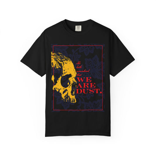 Certainly! Here’s a rewritten sentence using the provided product data: The "We Are Dust" Gothic heavyweight cotton unisex t-shirt features a yellow skull set against a blue floral background with bold red text, inspired by the compassion of Psalm 102 and the mercy of the Lord; available in black.