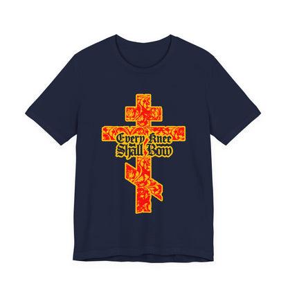 Navy unisex tee with a gold and red floral Orthodox cross and gothic “Every Knee Shall Bow” lettering, inspired by Isaiah 45:22-24 and Philippians 2:7-11.