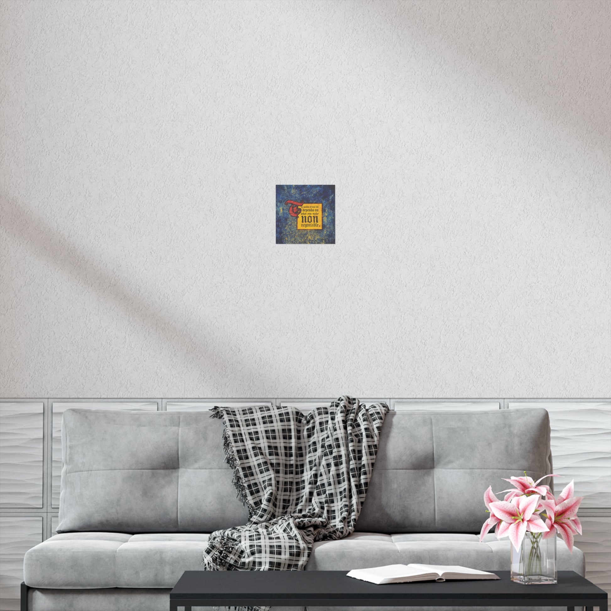 A cozy gray sofa, plaid blanket, and coffee table topped with flowers and an open book sit beneath "The Quality of Your Life Depends on What You Make Non-Negotiable" Orthodox Christian motivational art for inspiring comfort.