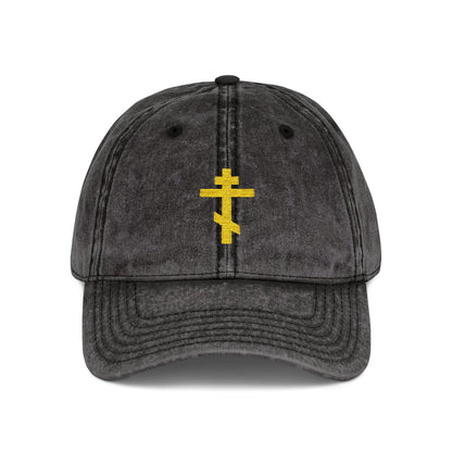 Black distressed cap with a minimalist yellow Orthodox TriBar Cross and "Crucify My Ego to the Precious and Life Giving Cross" embroidered on front—a simple statement of faith.