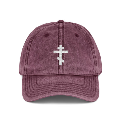 Maroon cap featuring a simple white Orthodox TriBar Cross embroidered on front, symbolizing Christ’s sacrifice; minimalist Christian design from the "Crucify My Ego to the Precious and Life Giving Cross" collection.