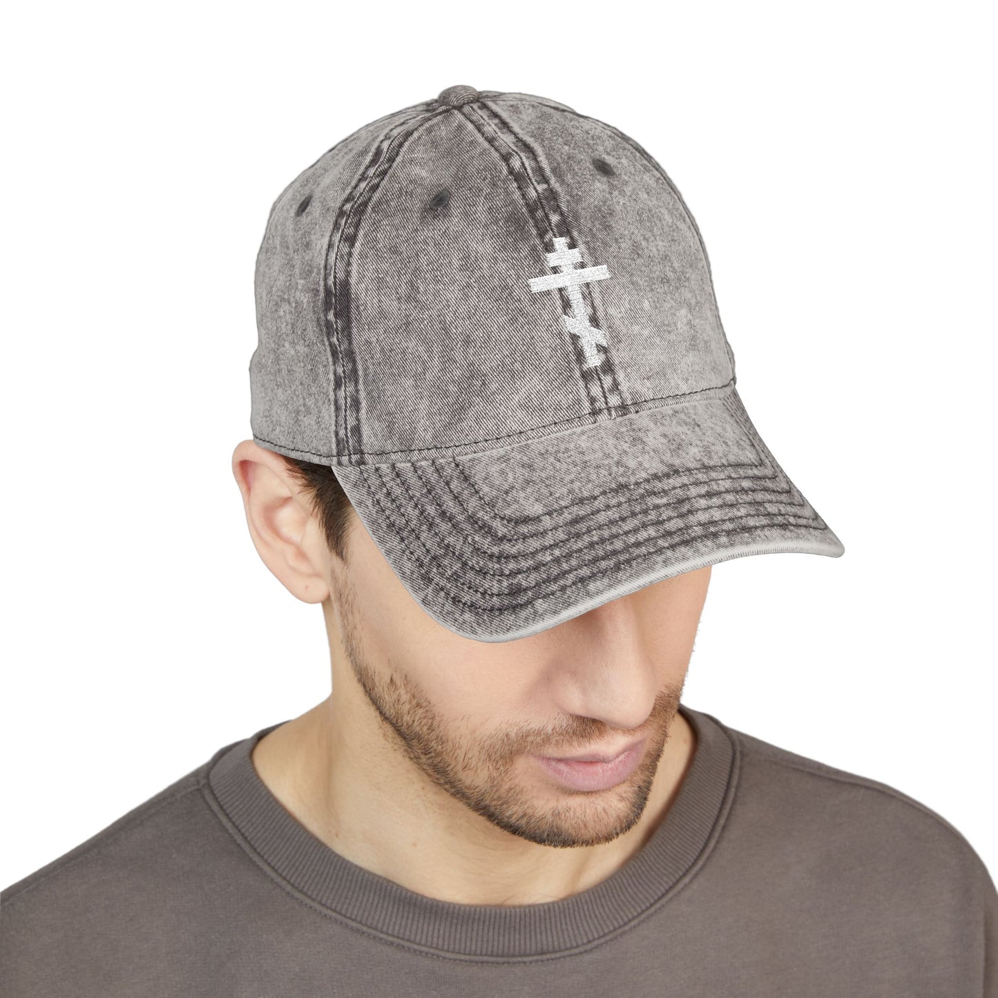 Man wears the Simple White Orthodox TriBar Cross minimalist cap—distressed grey with white embroidery—quietly reflecting on the meaning of the Crucify My Ego to the Precious and Life Giving Cross.