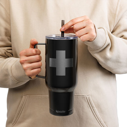 A person in a beige hoodie sips from a straw while holding the Minimalist Cross Engraved 40oz Koozie Tumbler—an insulated stainless steel Orthodox Christian home and travel accessory—featuring a simple cross design.