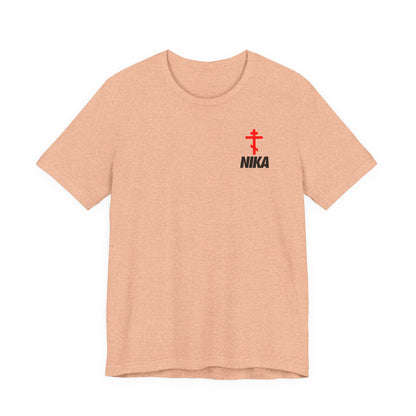Heather peach t-shirt featuring a small red Orthodox cross and bold NIKA text, inspired by the Nike logo mashup and symbolizing "Jesus Christ Conquers." Perfect for athletic ascetic Christian fashion.